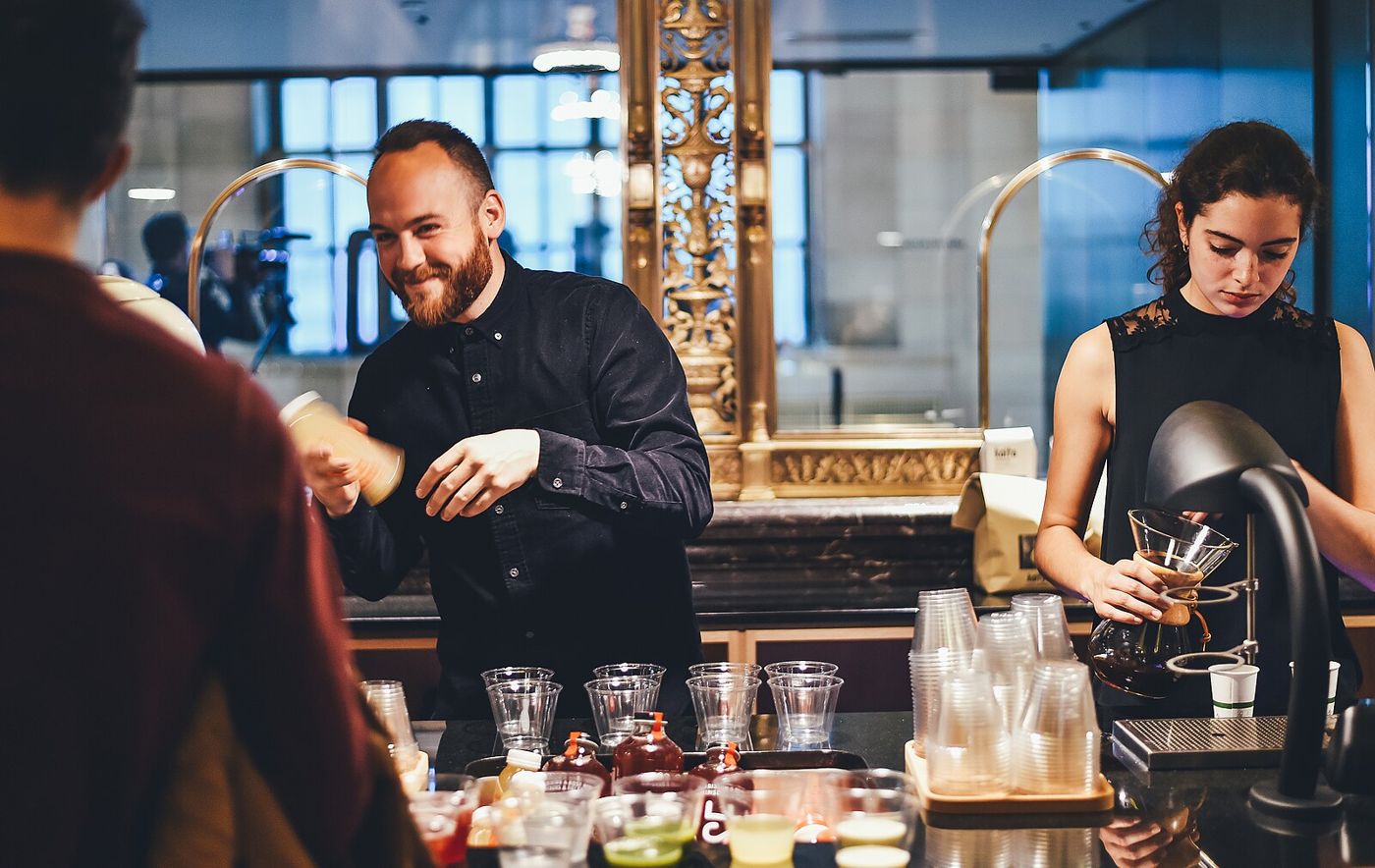 Bartenders preparing drinks at a lit bar