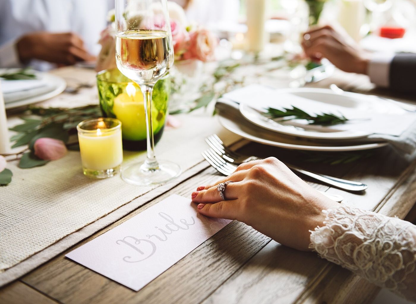 An elegantly set dinner table with candles and glassware